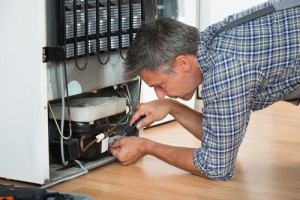 Man conducting fridge repair